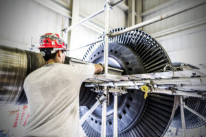 Employee works on large parts at nuclear power plant.
